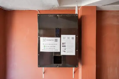 an orange wall with a ticket machine on it at XX Snap inn Sukhumvit 1 สแนป สุขุมวิท ซอย 1 in Makkasan
