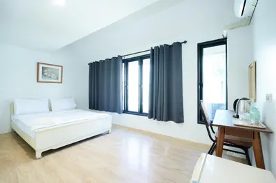 a living room with a white bed and windows at xx Snap Inn Sukhumvit 1 - สแนป อินน์ สุขุมวิท 1 in Makkasan