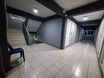 an empty hallway with a blue wall and a chair at Irich Theparak S207- Bts-Chang Erawan 2kms in Ban Khlong Hua Sakae
