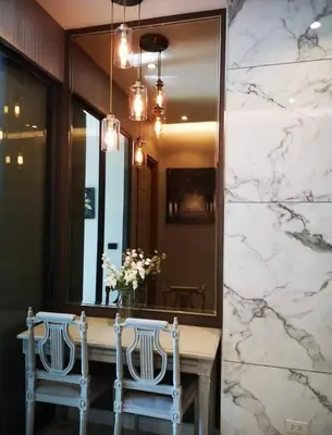 a dining room with two chairs and a mirror at Mayfair Bangkok in Bangkok