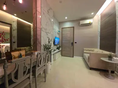 a bathroom with a couch and a sink and a tub at Mayfair Bangkok in Bangkok