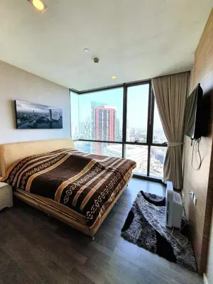 a bedroom with a large bed with a large window at The room, luxury condo 21fl 1 Bedroom ,near bts in Bangkok