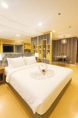 a bedroom with a large white bed with a flower on it at Modern Suite near BTS Nana Netflix Sky View in Makkasan