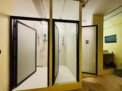 a bathroom with two glass doors and a shower at Sukhum Charoen Krung Tak-Sin bridge guest house in Bangkok