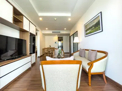 a living room with a couch and a television at Near BTS l Large 85 sqm l Rooftop Pool l Sontana in Bangkok