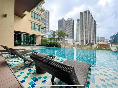 a swimming pool with chairs and a city skyline at Near BTS l Large 85 sqm l Rooftop Pool l Sontana in Bangkok