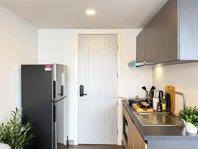 a kitchen with a refrigerator and a sink at Near BTS - Near Iconsiam - Pool and Gym - Sontana in Bangkok