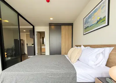 a bedroom with a large bed with white pillows at Near BTS - Near Iconsiam - Pool and Gym - Sontana in Bangkok