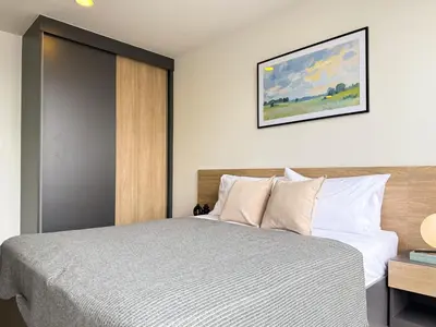 a bedroom with a bed and a picture on the wall at Near BTS - Near Iconsiam - Pool and Gym - Sontana in Bangkok