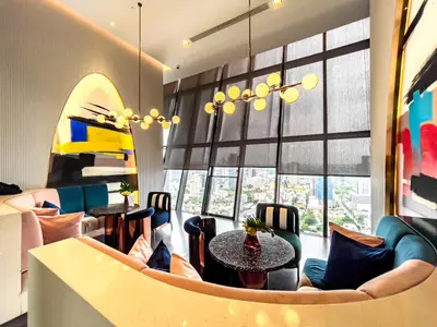 a restaurant with tables and chairs and a large window at Near BTS l Fully Furnished l Pool and Gym l Sontana in Bangkok