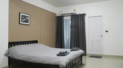 a bedroom with a bed with two towels on it at Baan Mai Guest House in Bangkok