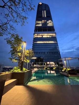 a tall building with a swimming pool in front of a building at Na casa da minha amiga in Bangkok