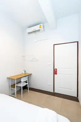 a white room with a desk and a white door at XX The Hidden Khaosan - เดอะ ฮิดเด้น ถนนข้าวสาร in Bang Bua Thong Railway Station