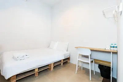 a bed in a room with a desk and a chair at XX The Hidden Khaosan - เดอะ ฮิดเด้น ถนนข้าวสาร in Bang Bua Thong Railway Station