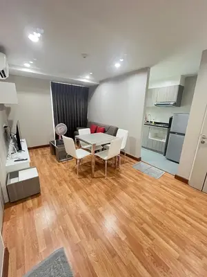 a living room with a table and chairs and a kitchen at AC Home 2 Laksi in Lak Si