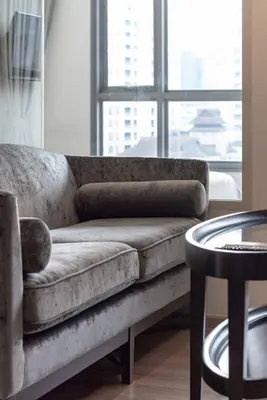 a couch sitting in a living room with a window at Free Airport Pick Up Rooftop Pool Gym near BTS Emquartier Shopping city center in Bangkok