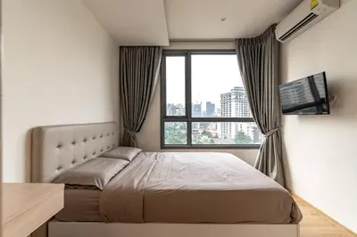 a bedroom with a bed and a large window at Free Airport Pick Up Rooftop Pool Gym near BTS Emquartier Shopping city center in Bangkok
