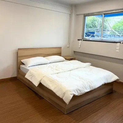 a bedroom with a bed with white sheets and a window at Box me in Bangkok