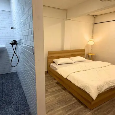 a bedroom with a bed and a camera on a wall at Box me in Bangkok