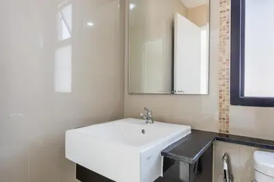 a bathroom with a white sink and a mirror at ZAYN Bangna Hotel in Bangna