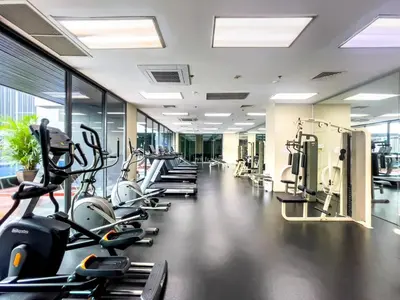 a gym with a row of cardio bikes and treadmills at BTS Thong Lol Large 52 sqm l Pool and Gym l Sontana in Bangkok