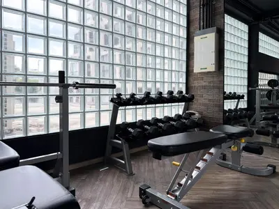 a gym with a bunch of equipment in front of a large window at Near BTS - Near Iconsiam - Pool and Gym - Sontana in Bangkok