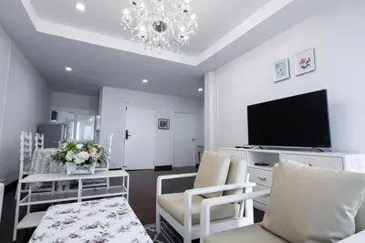 a living room with a tv and a chandelier at Blissful Heaven Residence at BTS Phromphong Emdistrict Shopping Area in Bangkok