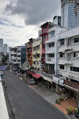 an empty street in a city with tall buildings at Blissful Heaven Residence at BTS Phromphong Emdistrict Shopping Area in Bangkok