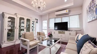 a living room with a chandelier and a tv at Blissful Heaven Residence at BTS Phromphong Emdistrict Shopping Area in Bangkok