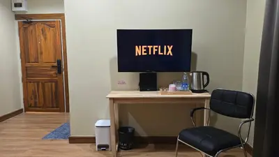 a monitor on top of a desk with a chair at Postel Chinatown in Bangkok