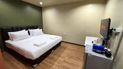 a bedroom with a large bed with white sheets at Postel Chinatown in Bangkok