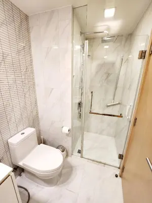 a white bathroom with a shower and a toilet at Prime 1BR in Sukhumvit 11 CentralStylishModern in Makkasan