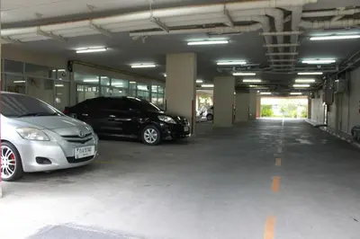 two cars parked in an empty parking garage at 14 Place in Bangkok