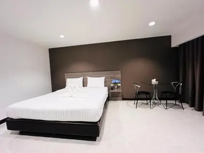 a bedroom with a bed and a table with chairs at 14 Place in Bangkok