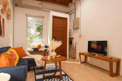 a living room with a blue couch and a tv at Soulful Stay-Hidden Thai-Mediterranean Retreat. in Bangkok