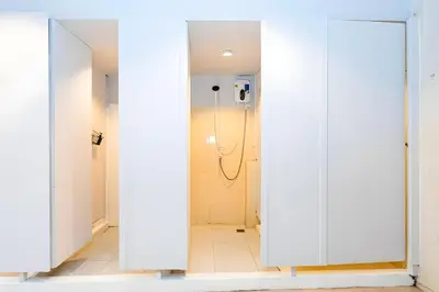 a bathroom with white doors and a shower at XX Mitr Inn Sukhumvit 2 - มิตร อินน์ สุขุมวิท 2 in Bang Kapi