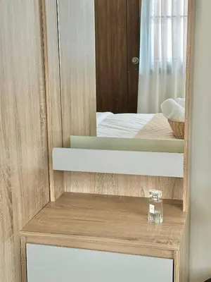 a mirror on top of a wooden cabinet with a drawer at Spacious 2BR2BA in Thonglor with WiFi & balcony in Khlong Toei