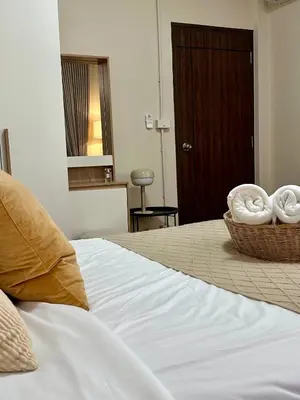 a bedroom with a bed with a basket of towels at Spacious 2BR2BA in Thonglor with WiFi & balcony in Khlong Toei
