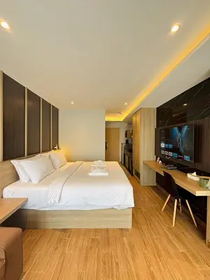 a bedroom with a bed and a desk and a television at J5 Hotel in Ban Zong Katiam