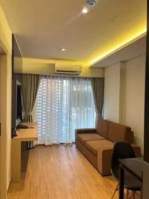 a living room with a couch and a table and a television at J5 Hotel in Ban Zong Katiam