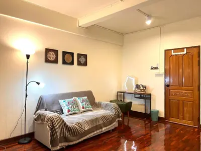 a living room with a couch and a lamp at Baan29 in Bangkok