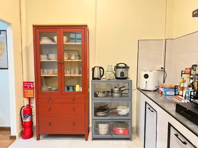a kitchen with a red cabinet with dishes in it at Baan29 in Bangkok