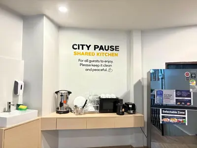 a city pause shaded kitchen with a sign on the wall at City Pause Hostel in Sathani Bang Su