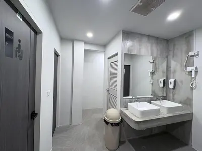 a bathroom with two sinks and a mirror at City Pause Hostel in Sathani Bang Su