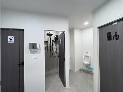 a bathroom with a shower and two urinals at City Pause Hostel in Sathani Bang Su