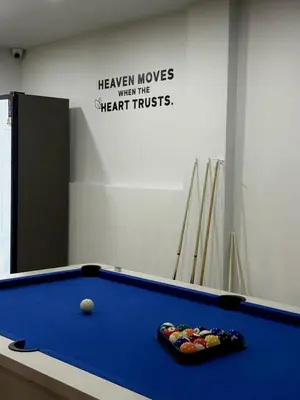 a pool table in a room with a sign at City Pause Hostel in Sathani Bang Su