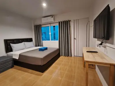 a bedroom with a bed and a desk and a television at D45 Home - BTS Ratchathewi N1 Station in Bangkok