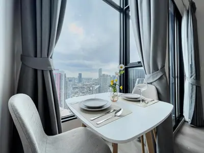 a white table and chairs in a room with a window at 250m BTS l Duplex Unit l Rooftop Pool l Sontana in Bangkok