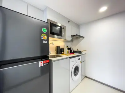 a kitchen with a washing machine and a microwave at 250m BTS l Duplex Unit l Rooftop Pool l Sontana in Bangkok