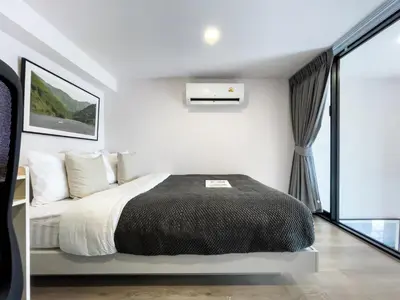a bedroom with a bed and a large window at 250m BTS l Duplex Unit l Rooftop Pool l Sontana in Bangkok